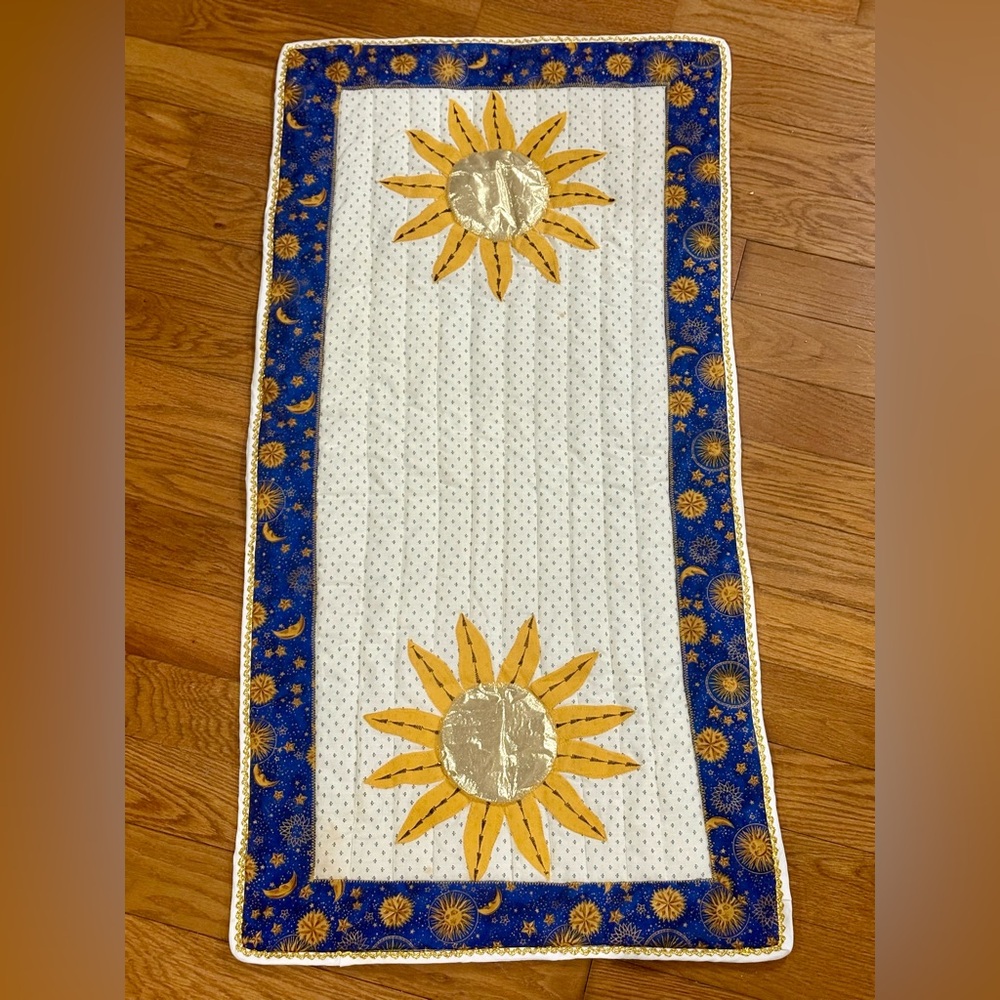 Quilted runner with sunflower appliqués and a blue sun and moon border